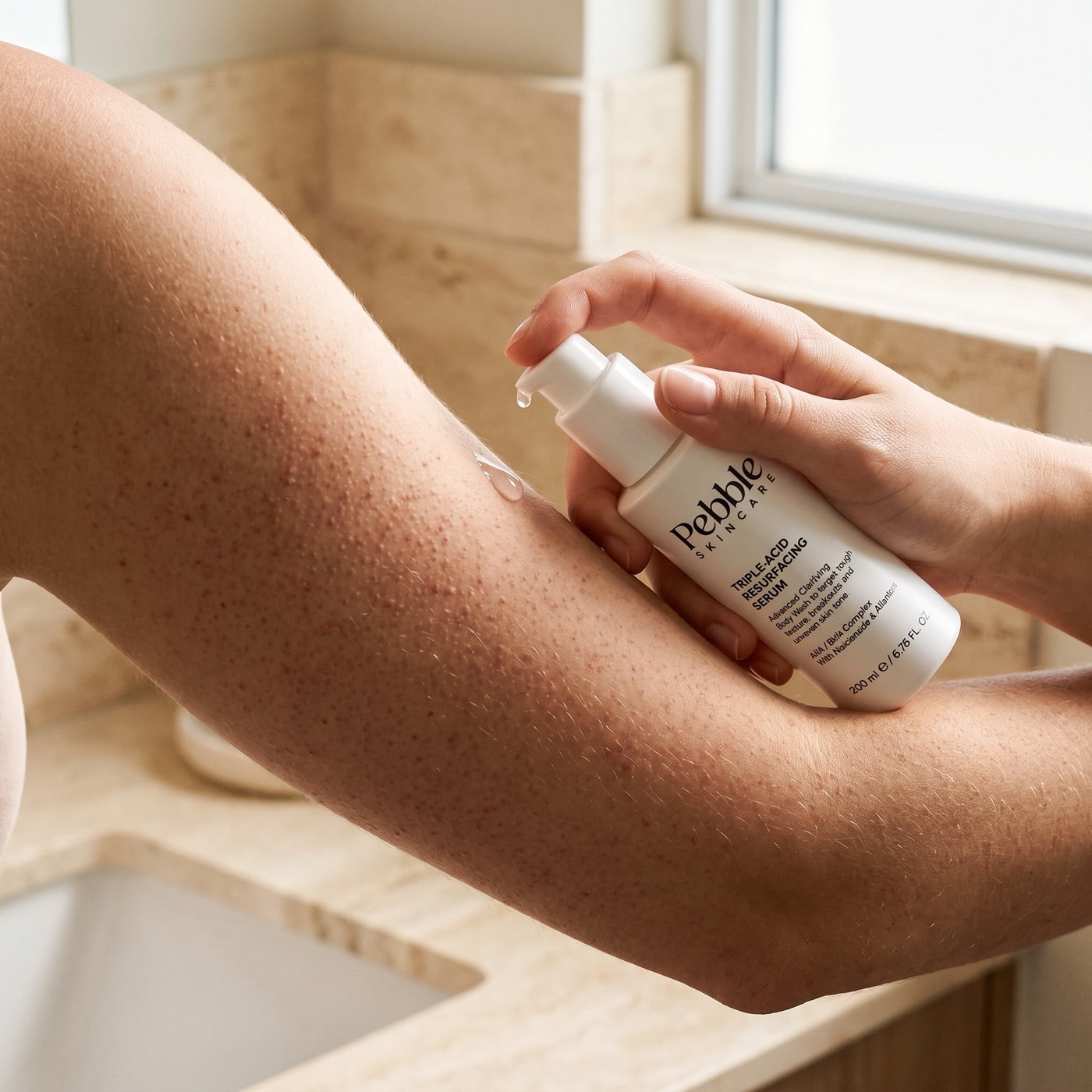 Serum being smoothed onto an upper arm with small bumps