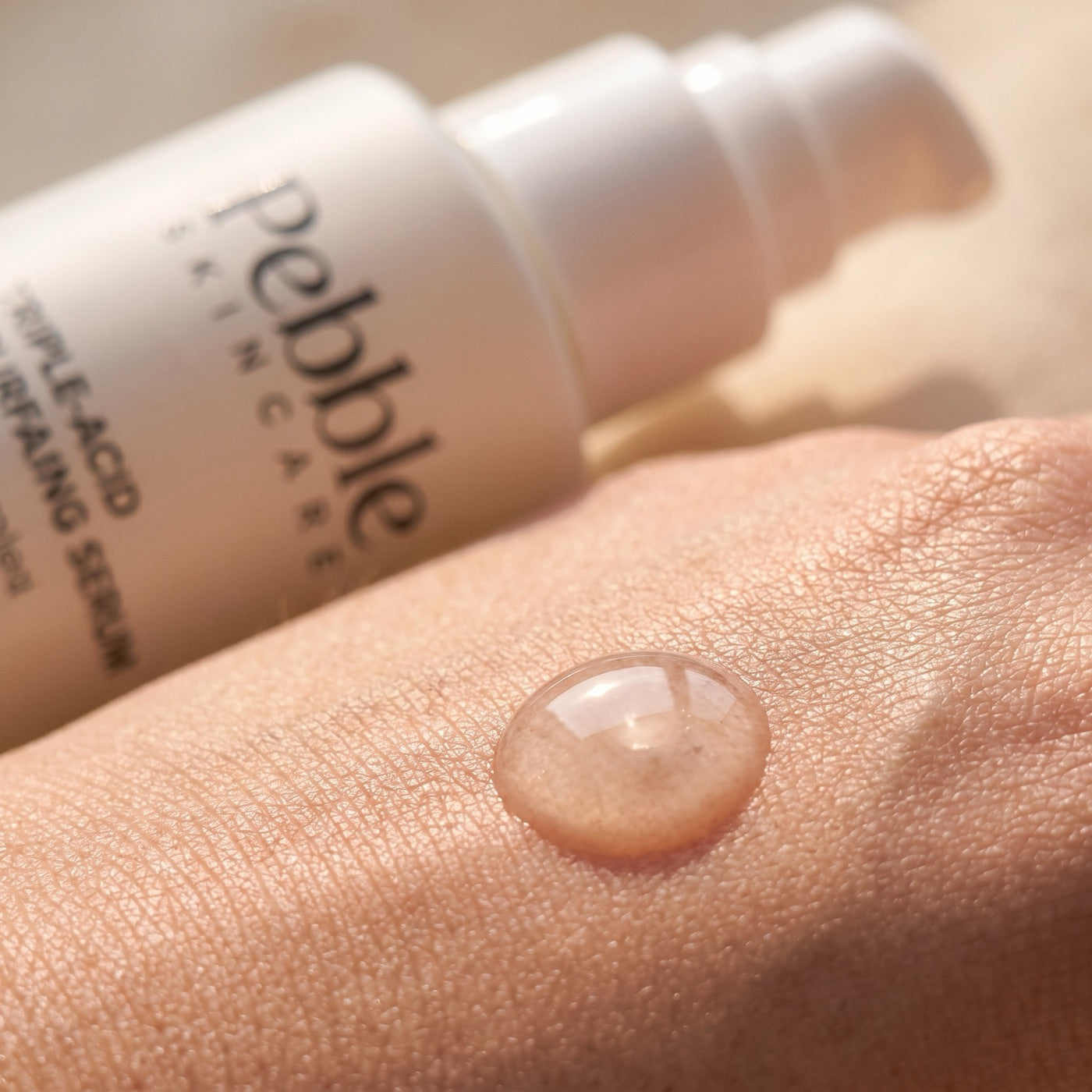 Macro of a clear serum drop on skin