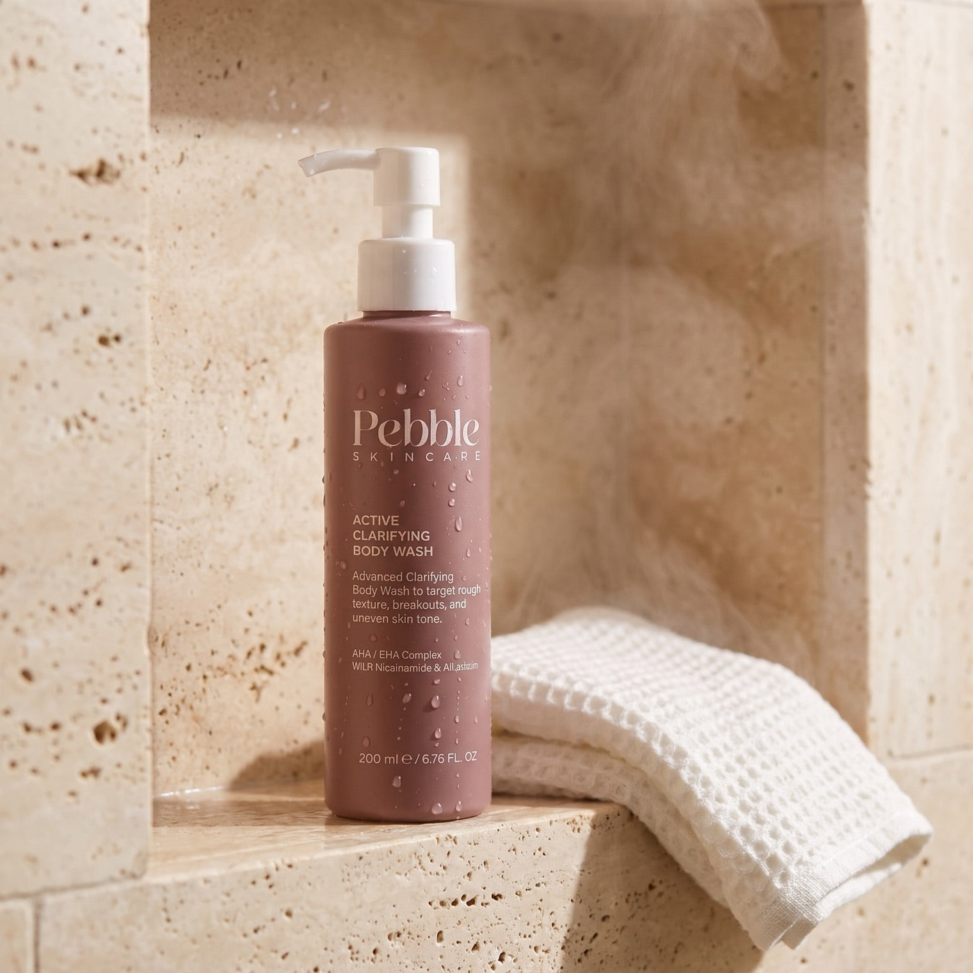 Active Clarifying Body Wash on a wet travertine shower ledge
